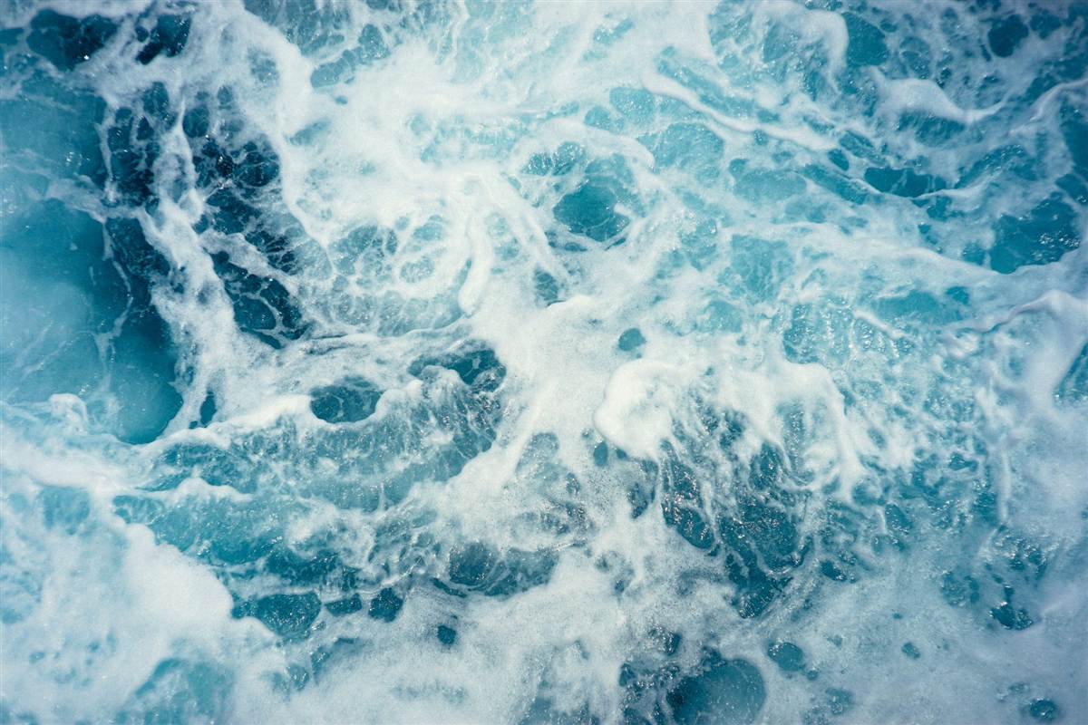 Écume blanche sur une mer turquoise en mouvement